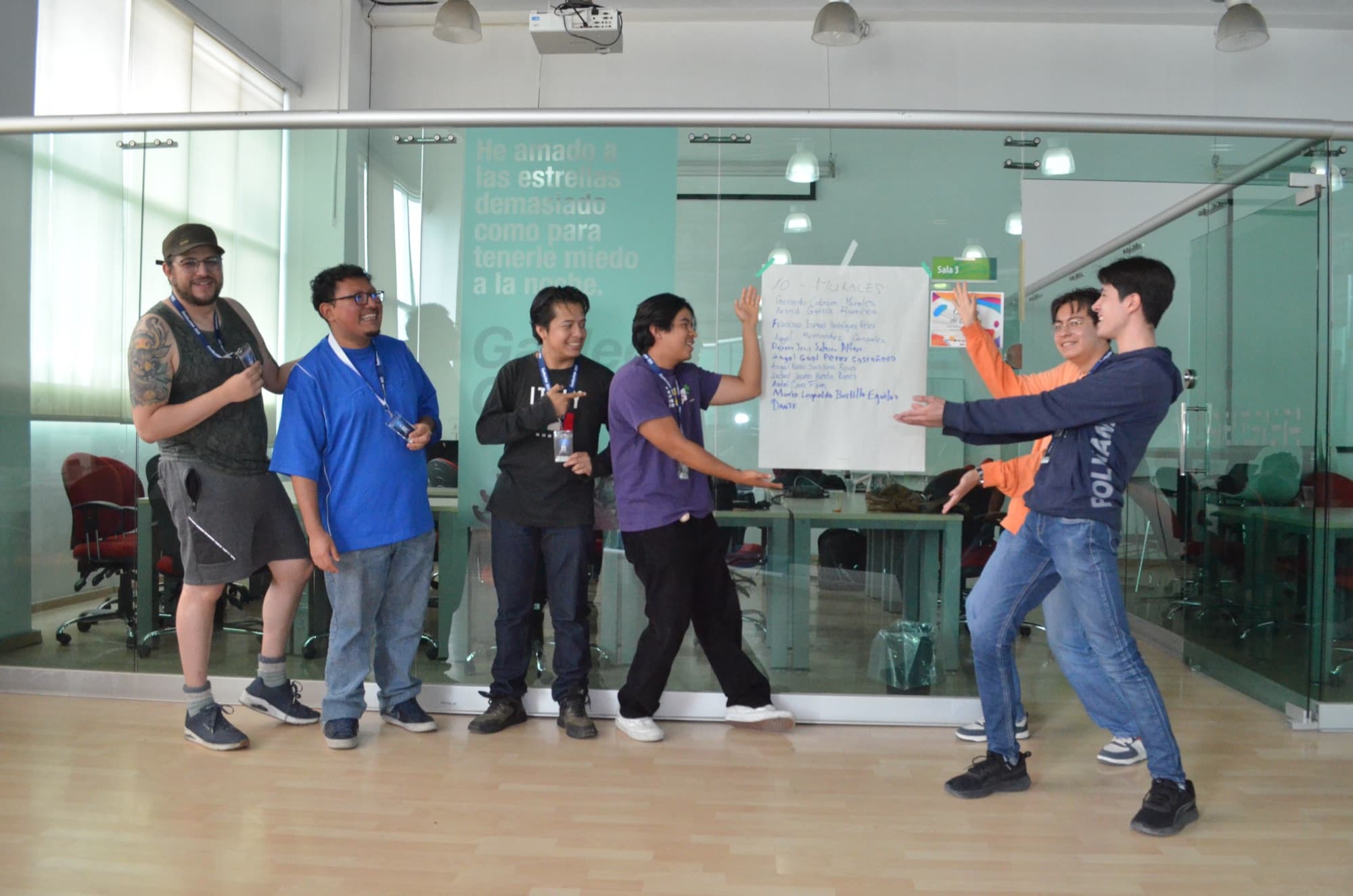 A team presents its idea in front of a flip chart while a teammate points at the plan.